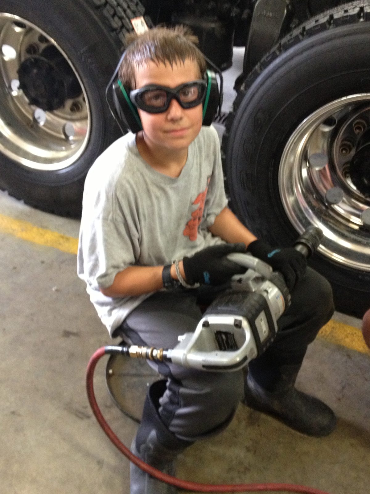 Justin as a pre-teen running an impact wrench on a truck wheel
