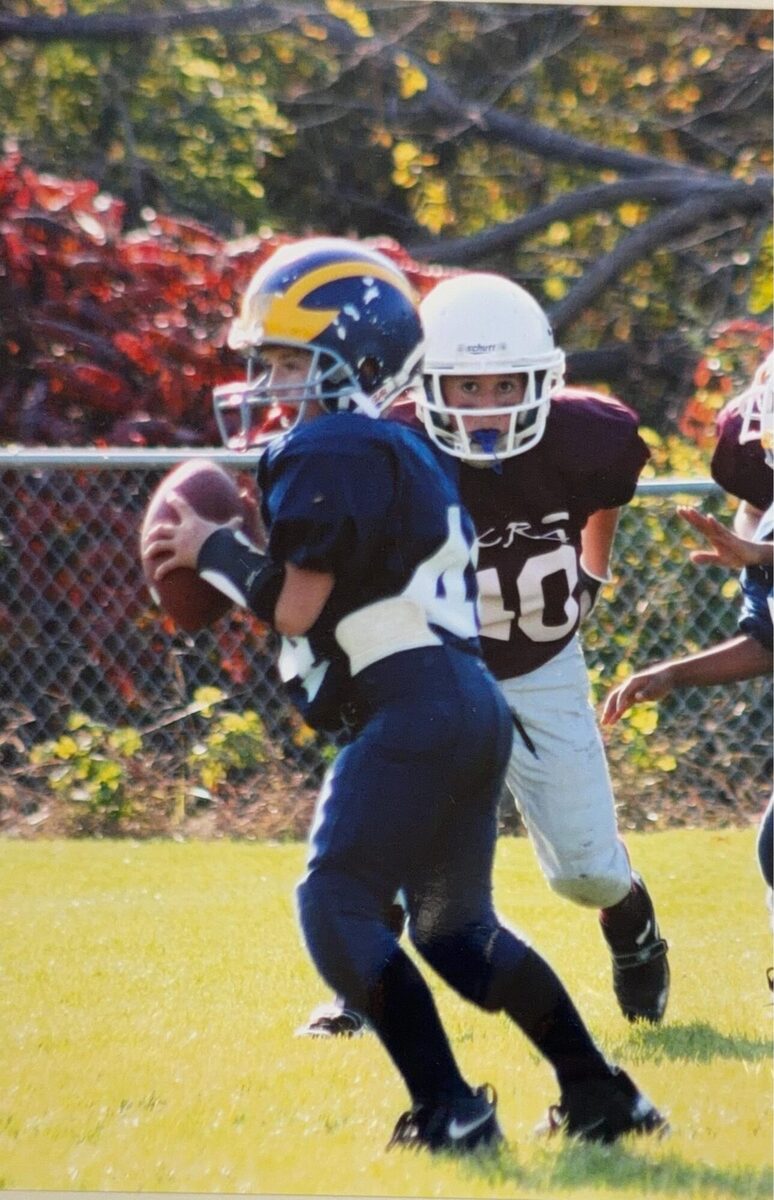 Justin carrying the ball in a youth tackle-football game